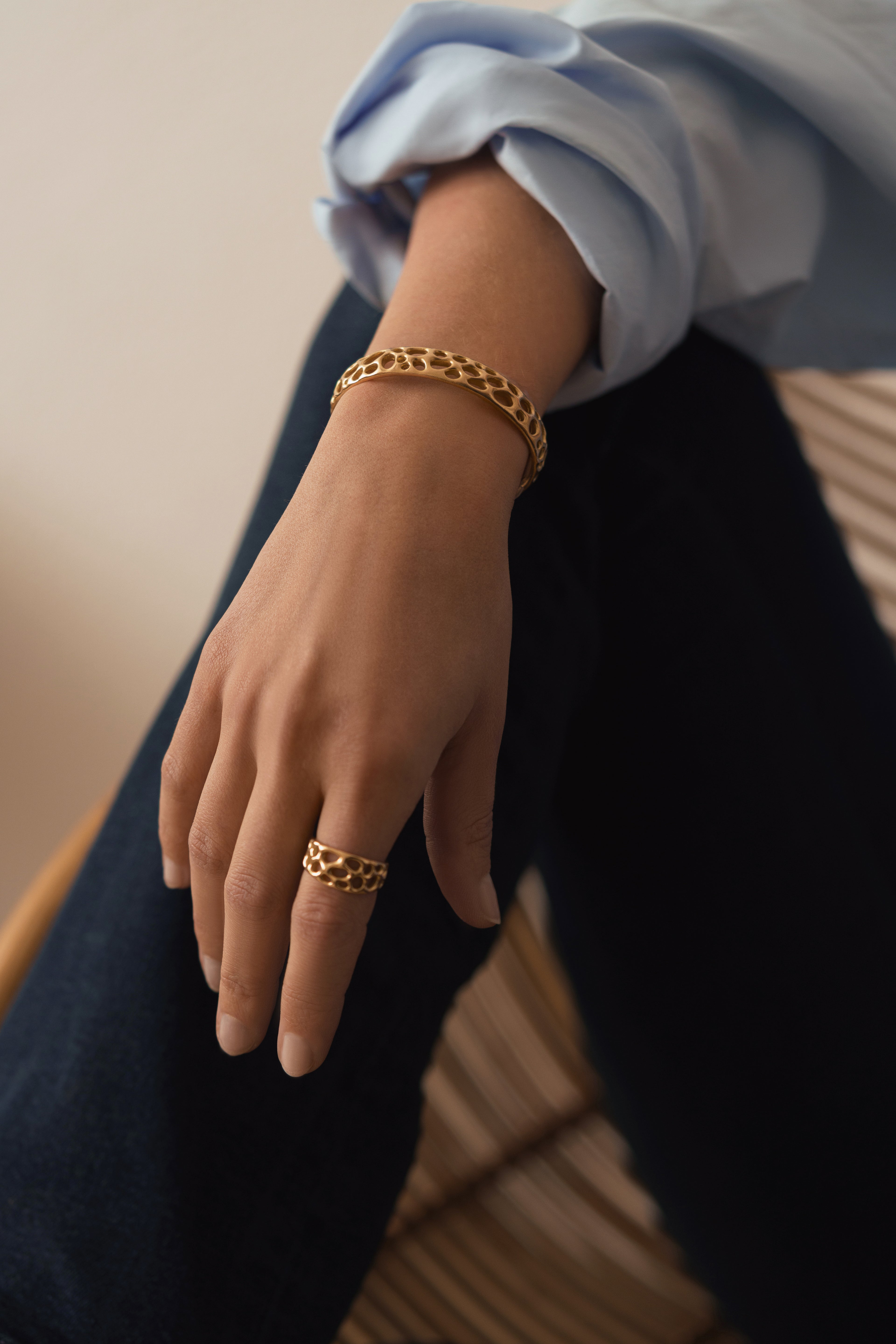 A lifestyle picture of Vesicular Voids bangle and ring in 18k rose gold